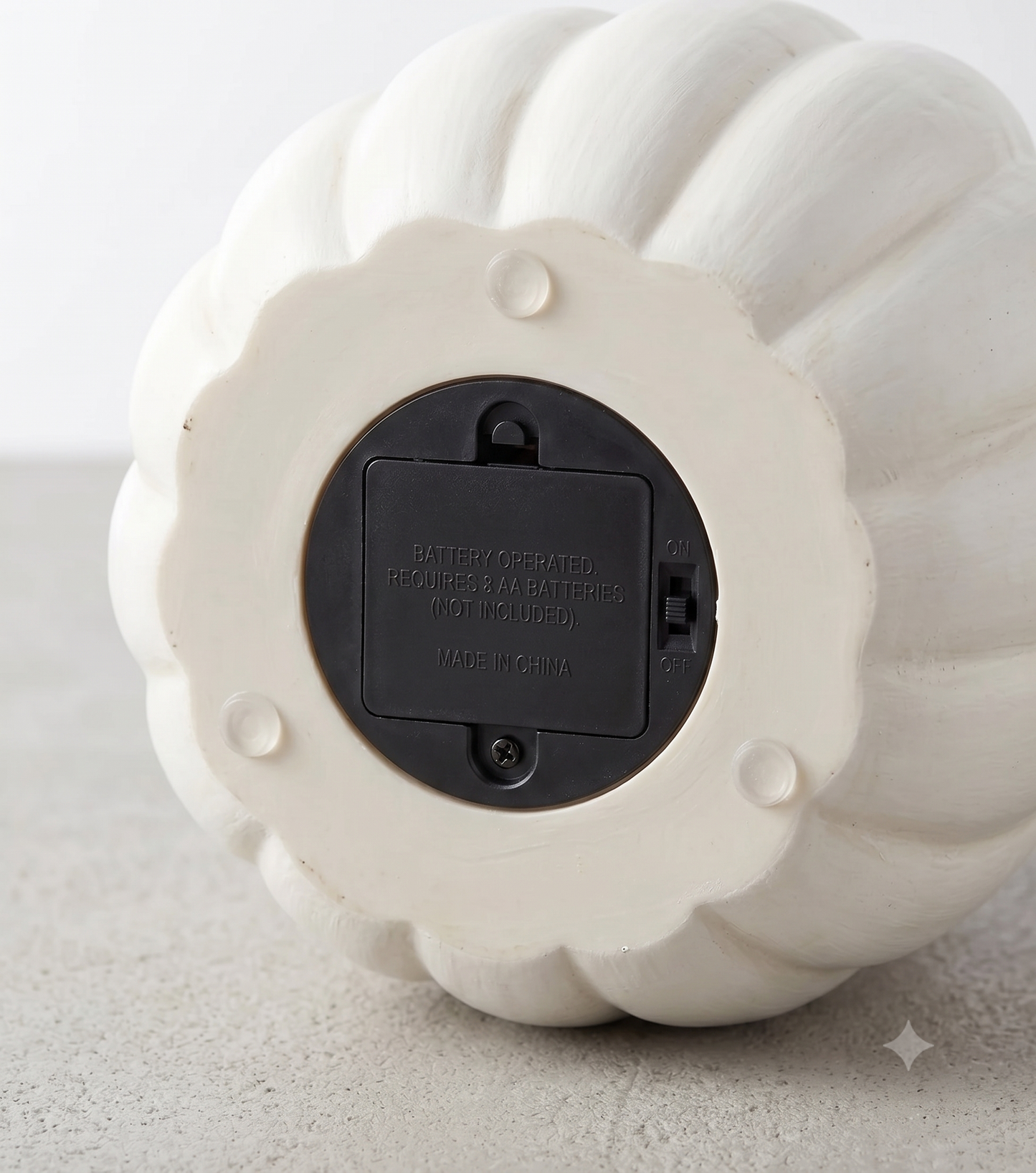The bottom base of the resin Halloween pumpkin showing the clean, cord-free battery compartment and power switch for the LED lights