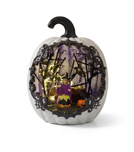 Light up white resin pumpkin decoration featuring an intricate miniature witch, cauldron, and black cat scene with warm glowing LED lights on a pure white background